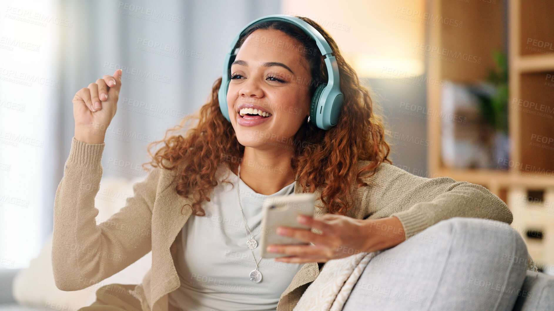 Buy stock photo Woman, headphones and music on sofa, phone or thinking with smile, listen and relax in home. Girl, smartphone and happy for audio streaming subscription, app and radio with dance on living room couch