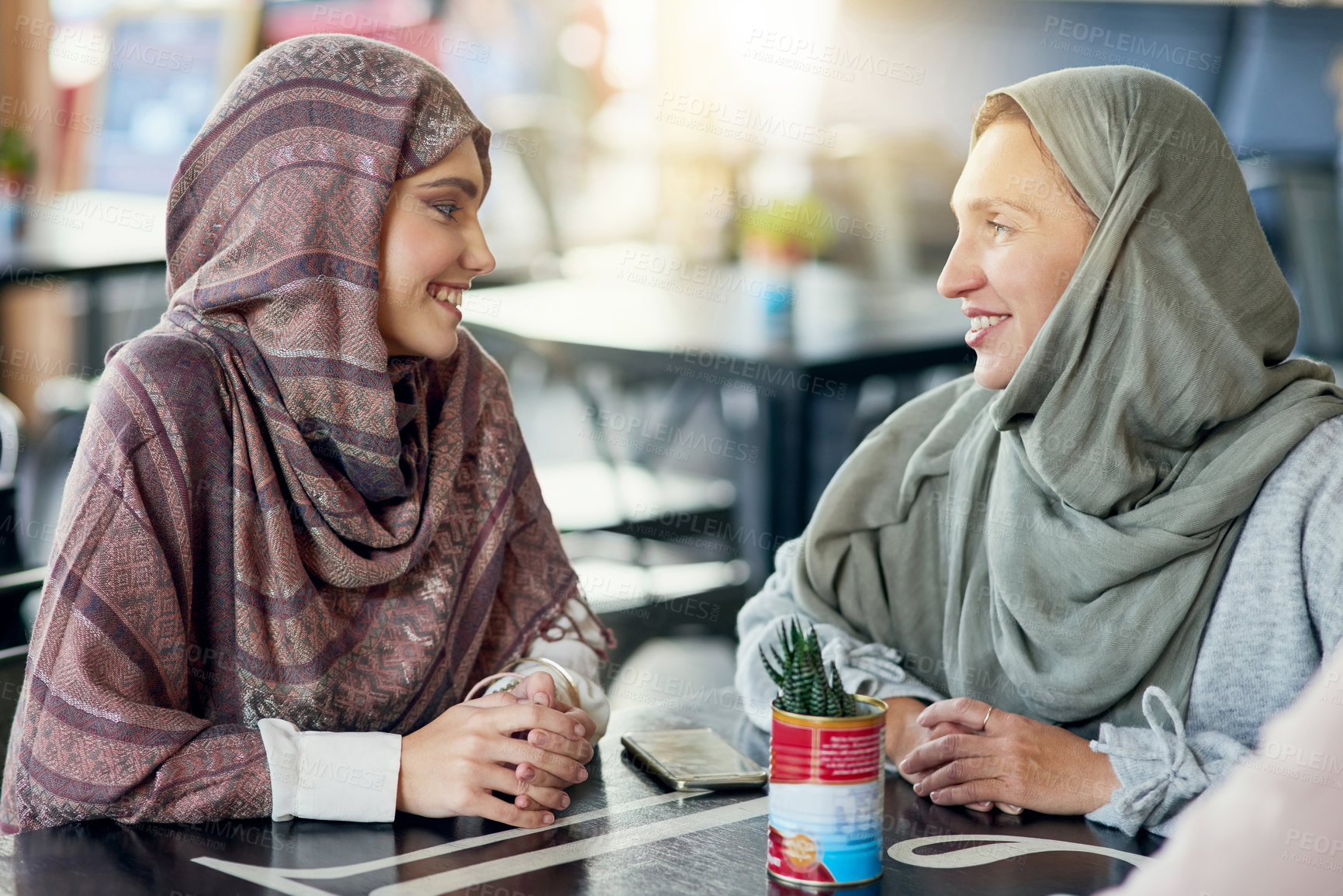 Buy stock photo Friends, happy and Muslim women in cafe, bonding and talking together. Coffee shop, relax and Islamic girls, group or people chat, conversation and discussion for social gathering in restaurant.
