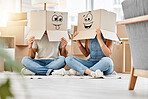 Couple and funny boxes with faces and smile drawn on them on their heads while moving house