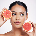 Woman, face and grapefruit for skincare vitamin C, beauty or cosmetics against a white studio background. Thinking female person holding fruit for healthy nutrition, natural healthcare or wellness
