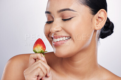 Buy stock photo Strawberry, face and beauty of a woman in studio for skincare glow, dermatology or natural cosmetics. Happy female person with fruit in hand for detox, healthy diet and wellness on a white background