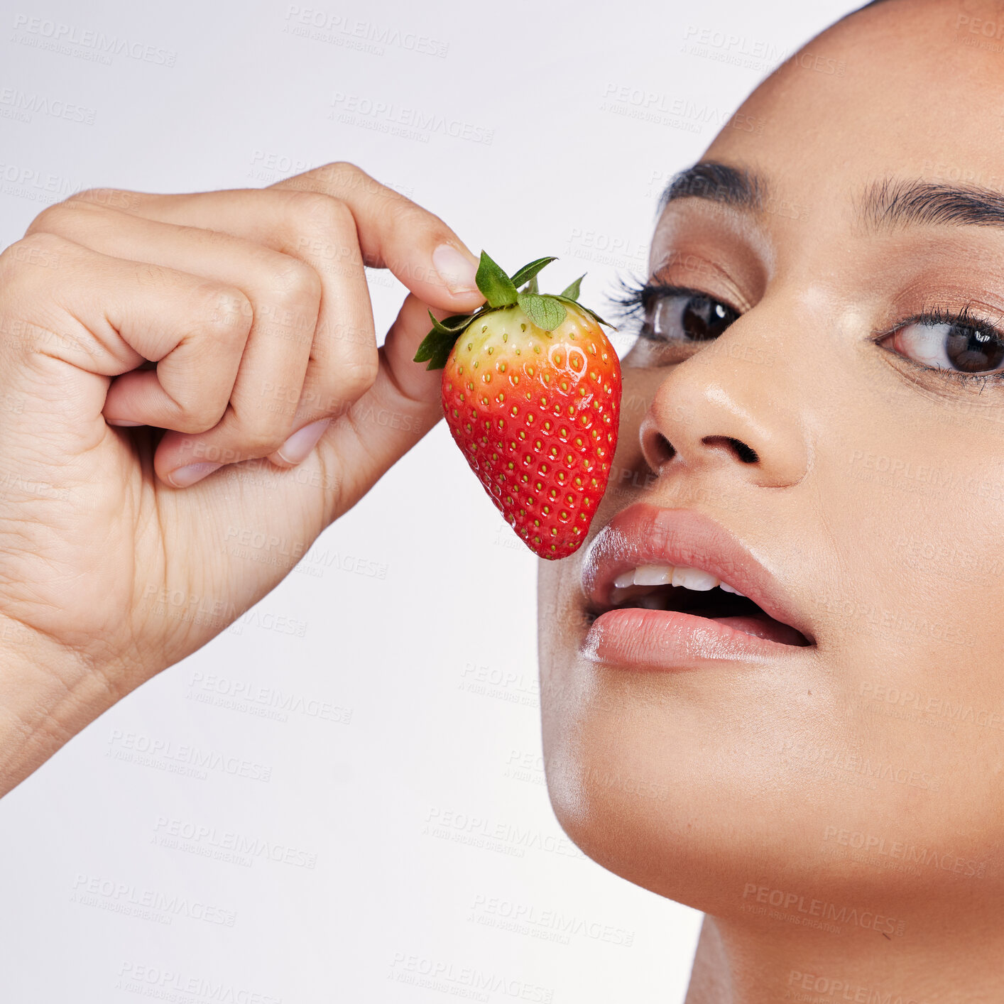 Buy stock photo Face, lips and strawberry portrait of a woman in studio for beauty glow, dermatology or natural cosmetics. Female person with fruit in hand for detox, healthy diet and skincare on a white background