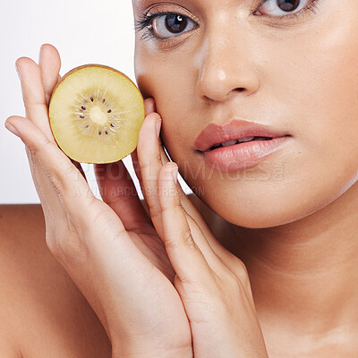 Buy stock photo Woman, portrait and kiwi for natural skincare, vitamin C or beauty cosmetics against a white studio background. Closeup face of female person holding organic fruit for healthy nutrition or wellness