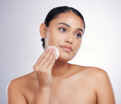 Buy stock photo Face, cleaning and cotton on skin of a woman in studio for natural beauty, dermatology or cosmetics. Female person with skincare wipe in hand for glow, healthy and clean facial on a white background