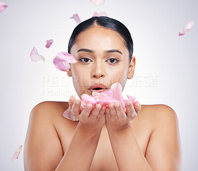 Buy stock photo Face, flower petals and beauty of a woman in studio for skin glow, dermatology and cosmetics. Female model blow flowers for facial skincare shine, health or wellness portrait on a white background