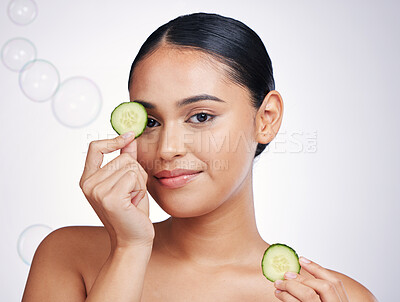 Buy stock photo Cucumber, face and beauty of a woman in studio for skin glow, dermatology and cosmetics. Portrait of model person with a vegetable in hand for natural facial, health or wellness on a white background