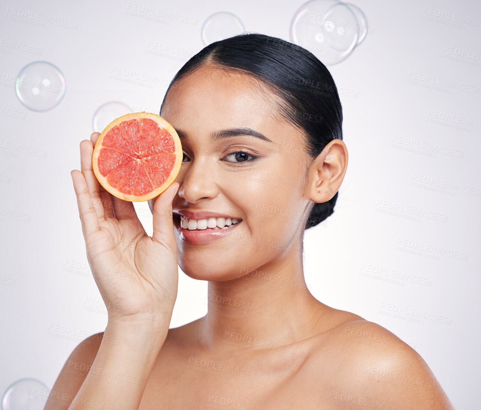 Buy stock photo Face, grapefruit and beauty portrait of a woman in studio for glow and natural dermatology. Female person with a fruit in hand and bubbles for facial detox, vitamin c and health on a white background