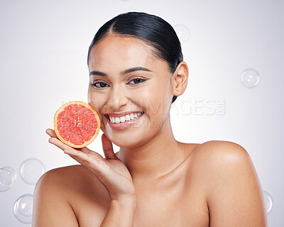Buy stock photo Face, grapefruit and beauty portrait of a woman in studio for skin glow, dermatology or natural cosmetic. Happy person with fruit and bubbles for detox, healthy diet or skincare on a white background