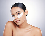 Face, eye mask and beauty of a woman in studio for glow, dermatology or natural cosmetics. Portrait of model person with collagen skincare patch for facial self care or wellness on a white background