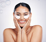 Face, portrait of woman with cream and against a studio background with happy smile. Cosmetics or makeup product, skincare wellness and young female person with skin treatment against backdrop