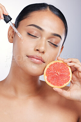 Buy stock photo Woman, face and serum with beauty and grapefruit, skincare oil with natural cosmetics isolated on studio background. Fruit, female model with pipette and vitamin c acid for skin with dermatology