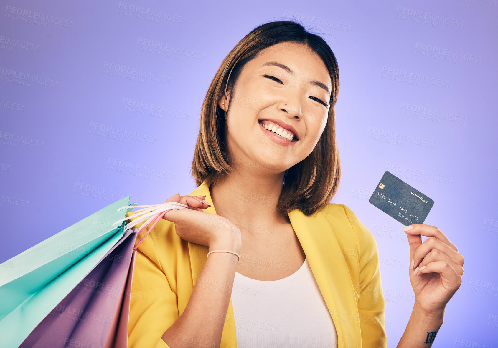 Buy stock photo Asian woman, credit card and shopping bag in studio portrait with smile for deal, sale or discount by background. Japanese girl, retail and happy with banking, budget or luxury by purple background