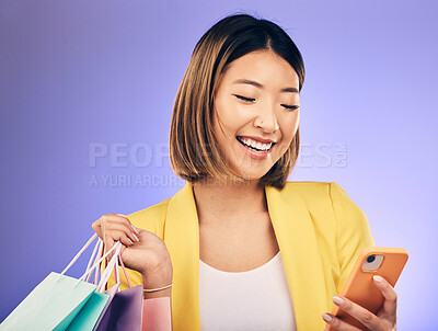 Buy stock photo Asian woman, phone and shopping bag in studio, texting and smile for deal, sale or discount by background. Japanese girl, retail and happy with social media, contact and luxury by purple background