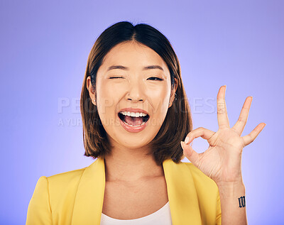 Buy stock photo Portrait, smile and Asian woman with ok sign, wink and emoji against a studio background. Face, female person and model with happiness, hand gesture and symbol for thank you, perfect and approval