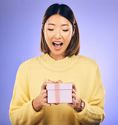 Buy stock photo Happy, surprise and woman with a gift in a studio for birthday celebration with a wow face. Happiness, excited and Asian female model with a present, box or package isolated by a purple background.