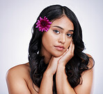 Beauty, portrait and woman with flower in hair, natural makeup and salon treatment on white background. Nature, hairstyle and flowers, face of latino model with organic haircare on studio backdrop.