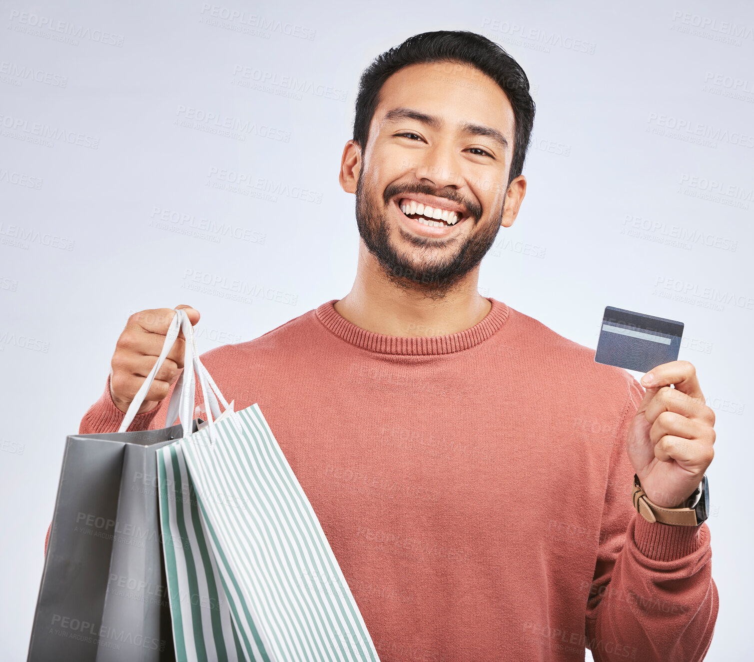 Buy stock photo Man is laughing with shopping bag, credit card and happy about discount at boutique isolated on studio background. Humor, funny and male person with payment for purchase, luxury and retail with sale