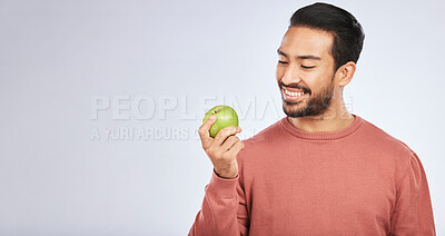 Buy stock photo Man, apple and nutrition, health and diet, mockup space and eating isolated on studio background. Male person with smile, green fruit and organic with healthy food, vegan with detox and lose weight