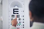 Eye care, medical and chart for a vision test for prescription lens glasses in an optometry clinic. Ophthalmology, healthcare and back of optometrist doing an optical exam with letter board in store.