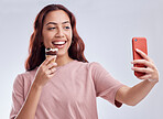Girl, ice cream and selfie with smile in studio for summer vacation, social media app and blog by white background. Woman, gelato or dessert with photography, profile picture and happy by backdrop