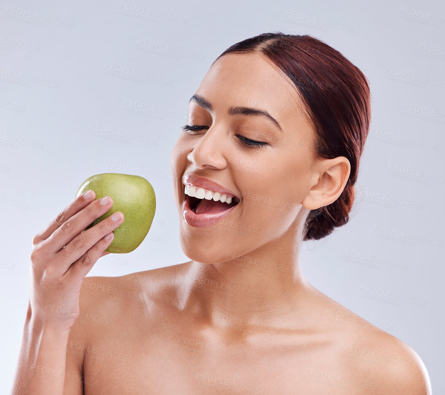 Buy stock photo Apple, happy or woman in studio eating on white background for healthy nutrition or clean diet. Bite, smile or hungry beautiful girl advertising or marketing natural organic green fruits for wellness