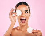 Happy woman, face and cotton pad in beauty, makeup removal or skincare cosmetics against a pink studio background. Excited female person or model with cosmetic swab for cleaning or facial treatment