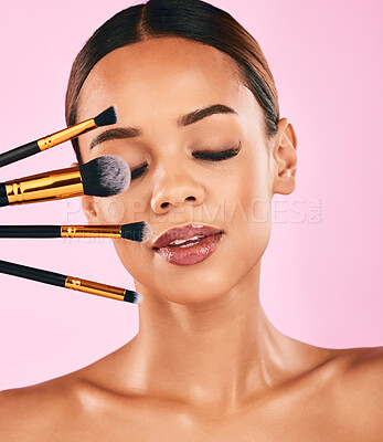 Buy stock photo Woman, face and makeup brushes for beauty cosmetics against a pink studio background. Isolated female person or model with cosmetic tools or equipment for grooming, skin products or facial treatment