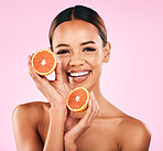 Happy woman, portrait and grapefruit for vitamin C, nutrition or natural skincare against a pink studio background. Face of female person with smile for organic fruit, healthy fiber diet or wellness