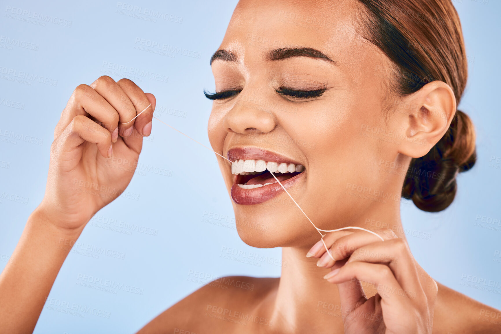 Buy stock photo Happy woman, dental floss and cleaning teeth for hygiene or healthcare against a blue studio background. Female person or model with smile in tooth whitening, flossing or oral, gum or clean mouth