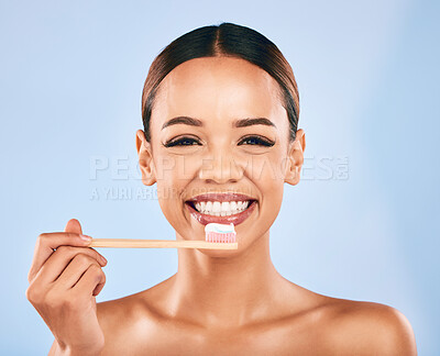 Buy stock photo Happy woman, portrait smile and toothbrush for dental hygiene or cleaning against a blue studio background. Female person or model smiling with tooth brush for clean teeth, oral or gum and mouth care