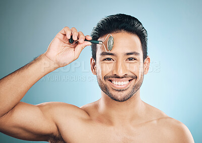 Buy stock photo Happy man, portrait or face massage with roller, facial product for healthy skincare on studio background. Relaxing, grooming treatment or male model smiling with dermatology cosmetics for beauty