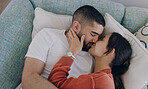 Top view of couple, love and kiss on sofa in living room for romance, intimacy and relax together at home. Young man, woman and kissing partner on couch for happy relationship, quality time and care