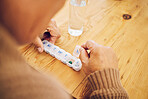 Elderly person, hand and pill box for daily medication, health and prescription medicine, sick and old age. Vitamins, supplements and senior with pills for the week, healthcare and retirement