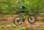 Motion blur, mountain bike and person cycling in forest for adventure, speed and fast power. Athlete, extreme sports and bicycle for outdoor action, off road transport and cardio race for adrenaline