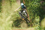 Bike, man and jump in forest for sports, cycling competition and adventure of action, challenge and contest. Bicycle, athlete and stunt performance in air for skill, adrenaline and freedom in nature