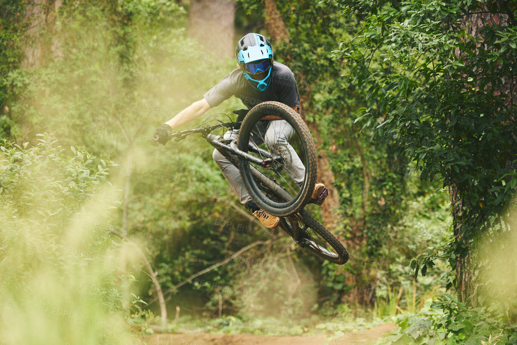 Buy stock photo Bike, man and jump in forest for sports, cycling competition and adventure of action, challenge and contest. Bicycle, athlete and stunt performance in air for skill, adrenaline and freedom in nature