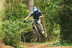 Mountain bike, man and jump in nature for cycling competition, action or adventure of extreme sports challenge. Bicycle, athlete and stunt performance in air for skill, adrenaline and freedom at park