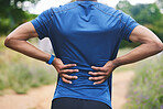 Sports, fitness and man with back pain in park after workout, exercise and marathon training in nature. Medical emergency, body health and male person with muscle strain, spine injury and joint ache