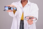 Glasses in hands, choice and vision with optometrist, prescription lens and frame isolated on studio background. Person with eyewear, ophthalmology and health insurance, product to help with eyesight