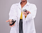 Glasses in hands, choice and vision with eye care, prescription lens and frame isolated on studio background. Person with eyewear, optometry and health insurance, product to help with eyesight