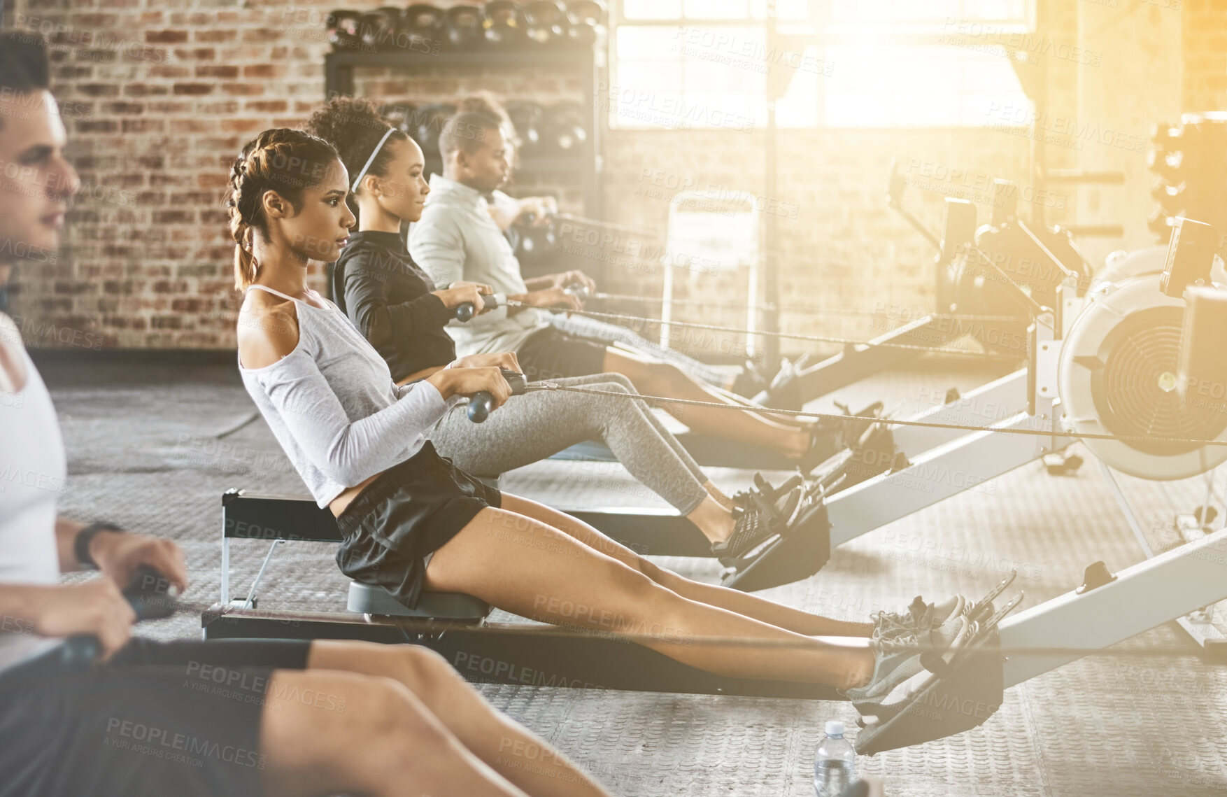 Buy stock photo Rowing machine, group and training in gym, class or fitness workout, exercise or cardio, row team and practice. People, healthy athlete and challenge on sport equipment, row crew and sports club