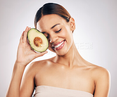 Buy stock photo Happy, skincare and woman with avocado in studio for natural, cosmetics or  facial on grey background. Smile, glow and girl model with fruit for vegan, environmental or skin detox with collagen 