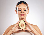 Skincare, beauty and woman with avocado in studio for organic, facial or treatment on grey background. Face, glow and girl model with fruit for eco, vegan or skin detox with anti aging antioxidants