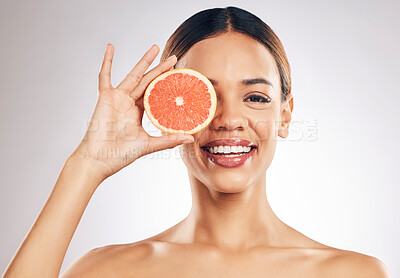 Buy stock photo Grapefruit, skincare and woman smile in studio for natural cosmetic, eco or beauty on grey background. Citrus, facial and female model relax with fruit for vegan, detox and vitamin c for glowing skin