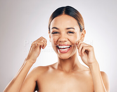 Buy stock photo Dental, smile and woman portrait flossing teeth in studio for hygiene, wellness or fresh breath on grey background. Face, floss and female relax with mouth, tooth or cleaning for oral care routine