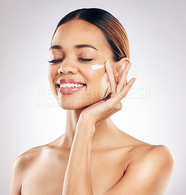 Buy stock photo Woman, cream on face and beauty with skincare, smile and moisturizer isolated on studio background. Happy female model apply lotion, dermatology and cosmetic product with skin glow and facial