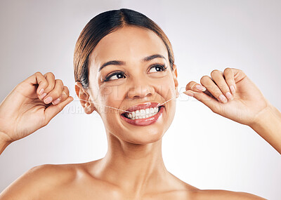 Buy stock photo Happy, dental and woman flossing teeth in studio for wellness, hygiene or fresh breath on grey background. Smile, floss and lady relax with mouth, tooth or cleaning for oral care or cavity prevention