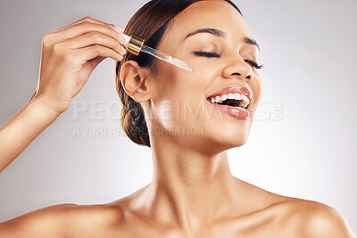 Buy stock photo Skincare, facial and happy woman with serum in studio for anti aging, cosmetic or luxury wellness on grey background. Facial, oil and female model smile for dermatology, retinol or CBD beauty product