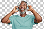 Happy mature African American man standing alone against isolated on a png background and wearing headphones to listen to music. Smiling portrait of senior black man with grey beard enjoying music