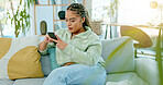 Black woman on sofa with smile, phone and coffee surfing internet, social media or web in living room. Relax, reading email or typing text, happy gen z girl on couch with smartphone on break with cup